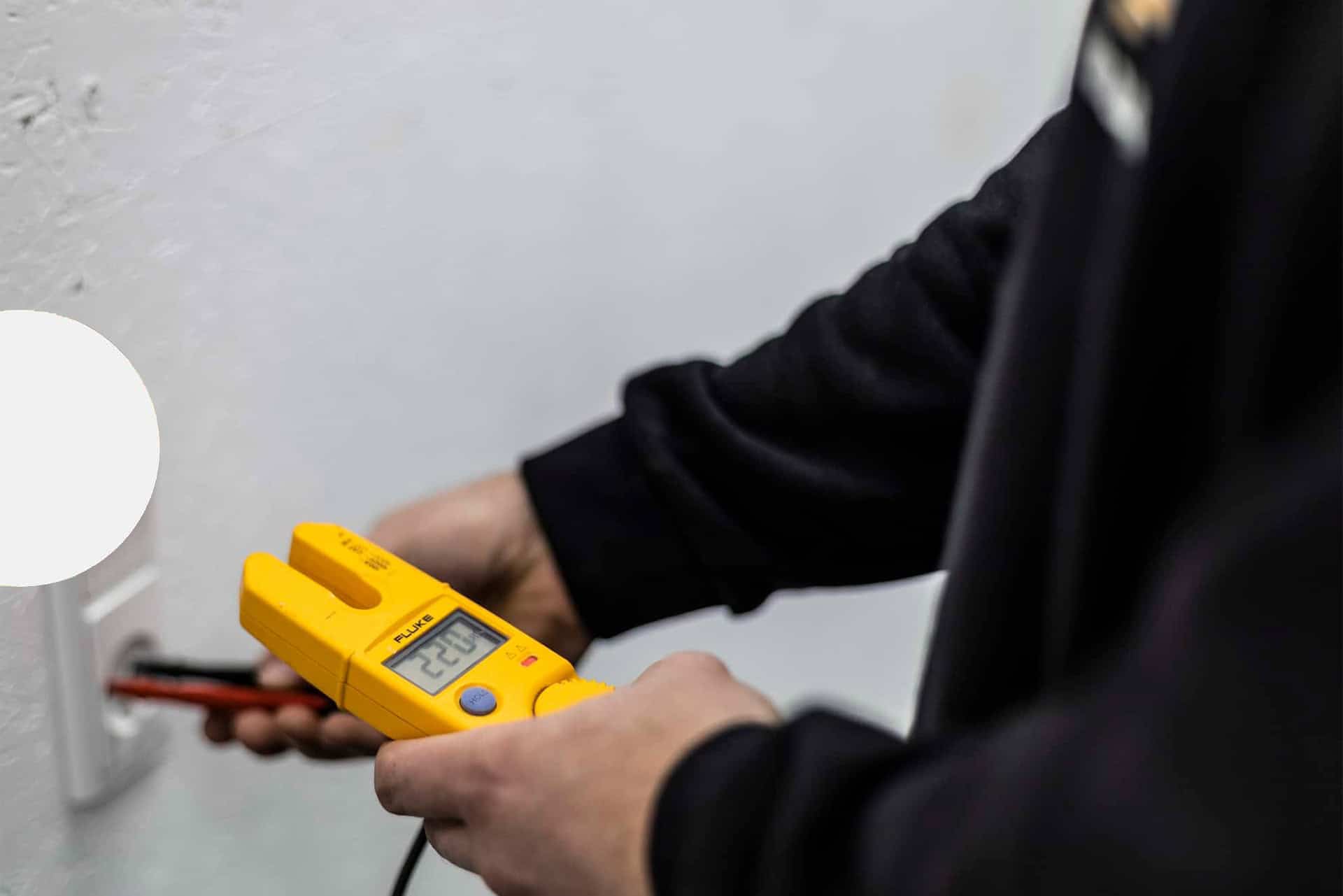 Elektriker bruger gul spændingstester til at tjekke elinstallation