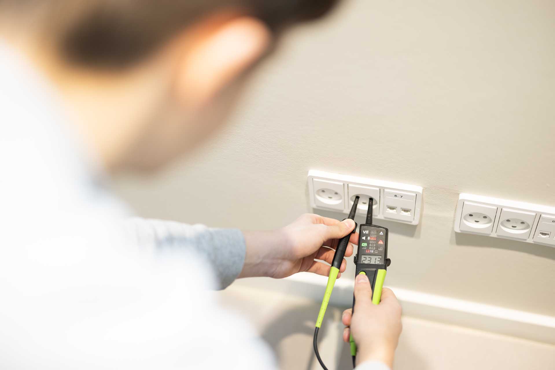 Elektriker monterer stikkontakt som del af el-entreprise projekt