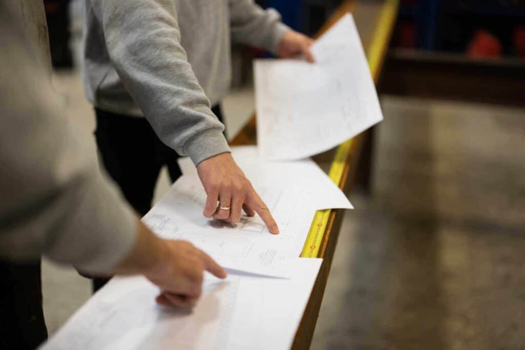 To medarbejdere gennemgår tekniske tegninger på værkstedet